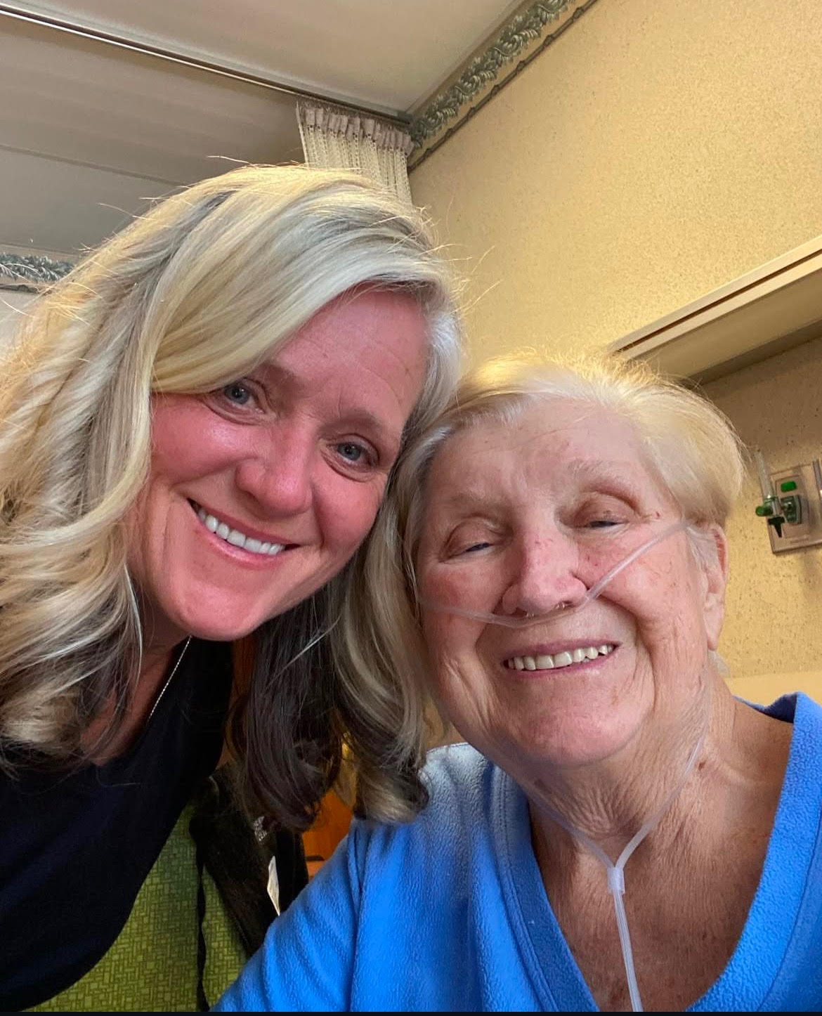 Two smiling women, one elderly and one younger, posing for a close-up selfie.