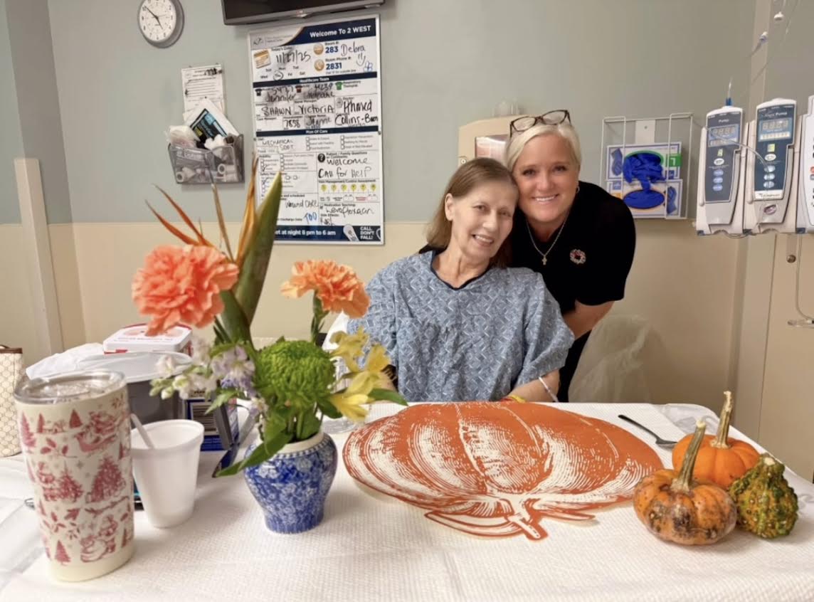 Two women smiling at autumn-decorated table