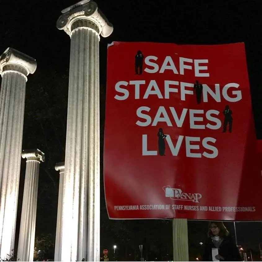 Red protest sign reading "Safe Staffing Saves Lives