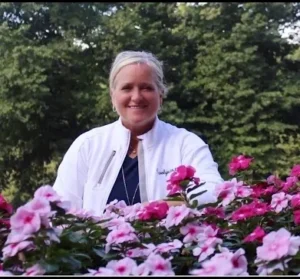 Smiling woman among pink garden flowers