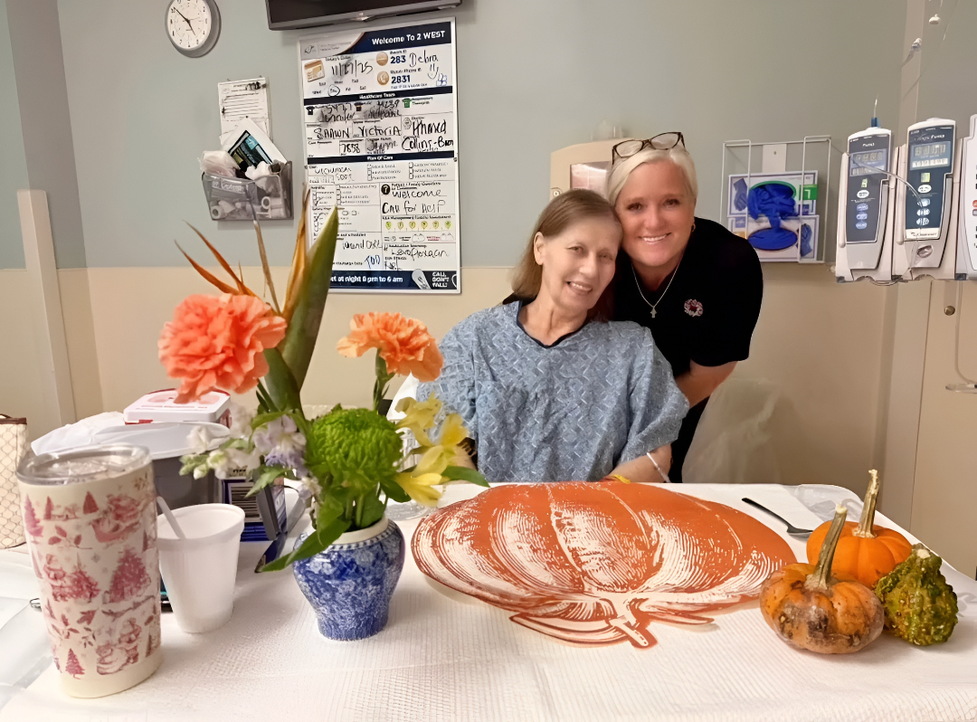 Smiling patient and caregiver with fall decorations