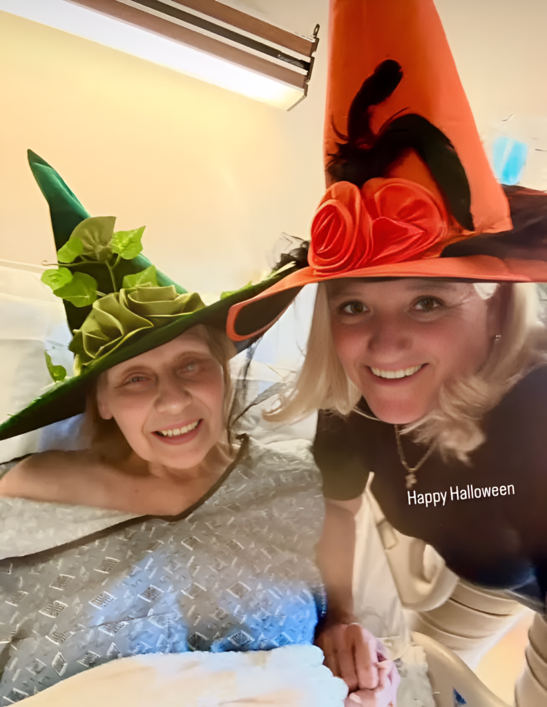 Smiling pair wearing green and orange witch hats