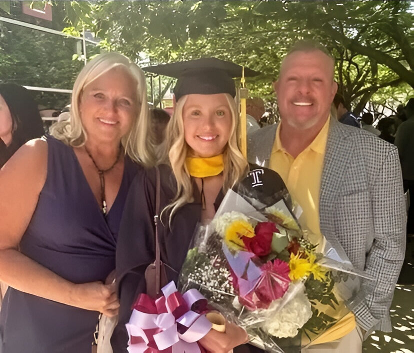 Young woman graduate with bouquet and parents
