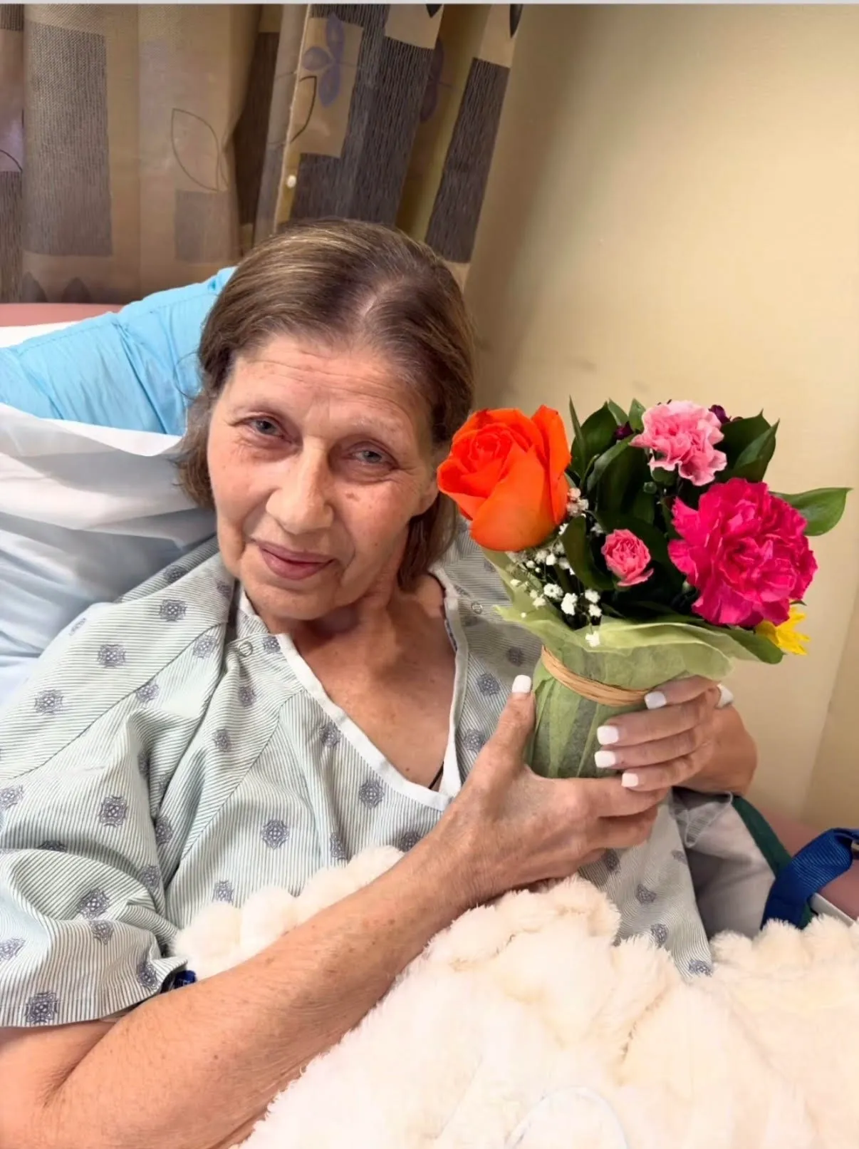 Woman holding bright bouquet in bed