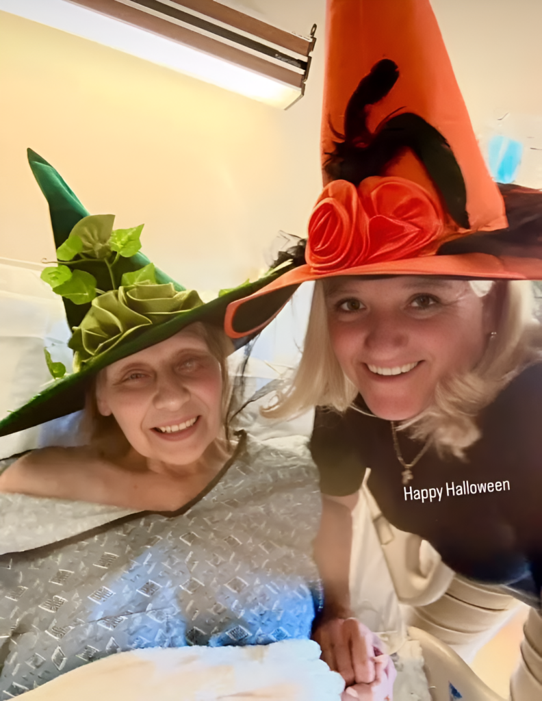 Two women smiling in Halloween witch hats