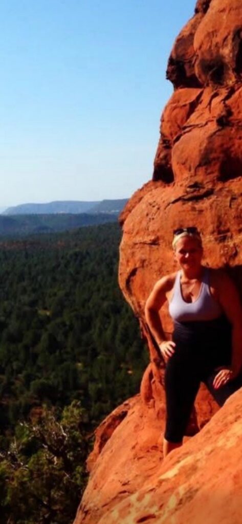 Woman hiking on red sandstone cliff