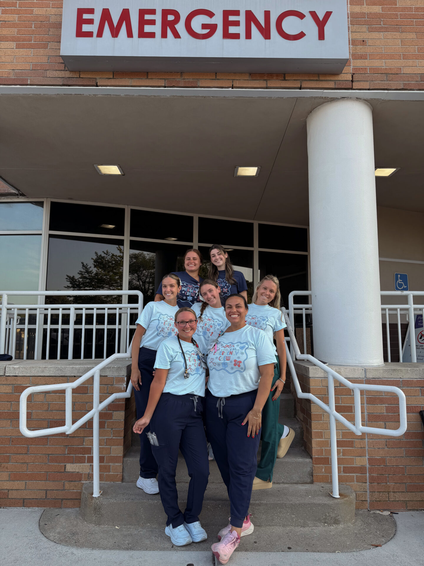 Group of healthcare workers outside emergency entrance.