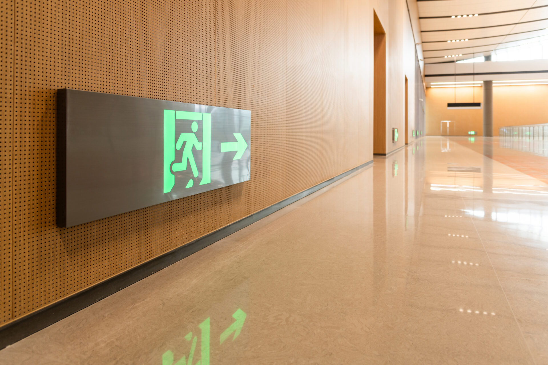 Illuminated exit sign in modern hallway.