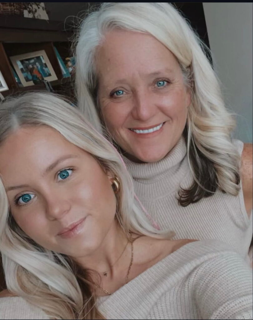 Two women posing together in matching outfits.